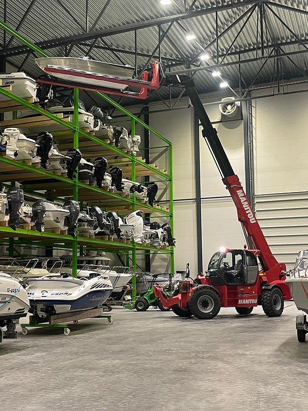 Manitou-kurottaja nostaa venettä säilytyshyllyille